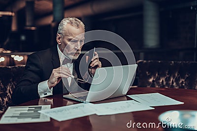 Old Businessman holding Pnone and glasses Stock Photo