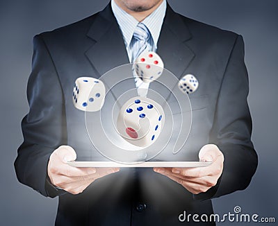 Businessman using tablet showing dice, risk management Stock Photo