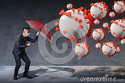 The businessman using an umbrella for defending coronavirus pandemic. the concept of insurance, protection, business and health ca Stock Photo