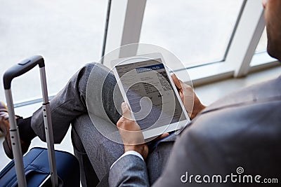 Businessman Viewing Boarding Pass In Airport Lounge Stock Photo