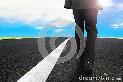 Businessman walking on asphalt road with sunlight blue sky Stock Photo