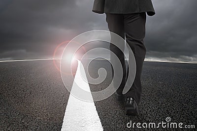 Businessman walking on asphalt road with sunlight cloudy sky Stock Photo