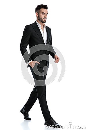 Businessman walking with one hand in pocket and one loose Stock Photo