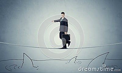 Businessman walking on rope above sharks Stock Photo