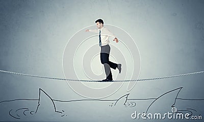 Businessman walking on rope above sharks Stock Photo