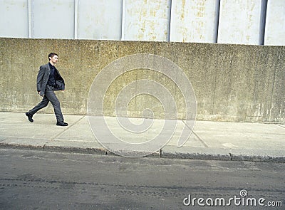 Businessman Walking On Sidewalk Stock Photo