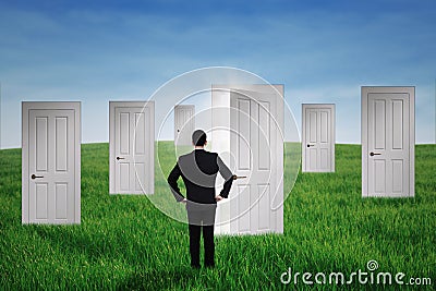 Businessman walking to opportunity doors Stock Photo