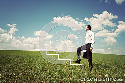 Businessman in walks up the ladder Stock Photo