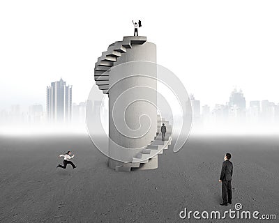 Businessman watching men with concrete spiral tower Stock Photo