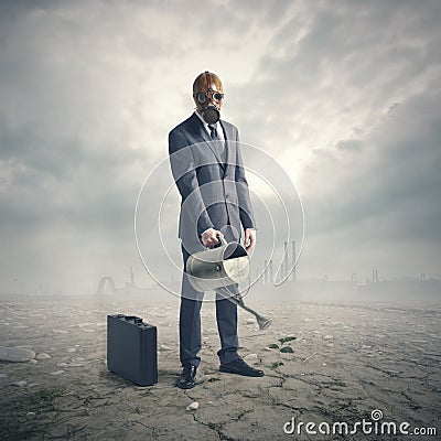 Businessman Watering Plant in Desert Stock Photo