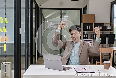 A businessman wearing a formal suit is at work. He sat in front of his laptop computer, Stock Photo