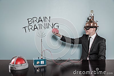 Businessman Wearing Helmet Holding Brain While Sitting By Text Stock Photo