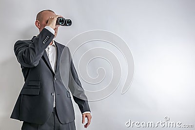 Businessman in white shirt and black suit scouts in binoculars. Stock Photo