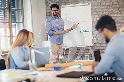 Businessman At Whiteboard Giving Presentation Stock Photo