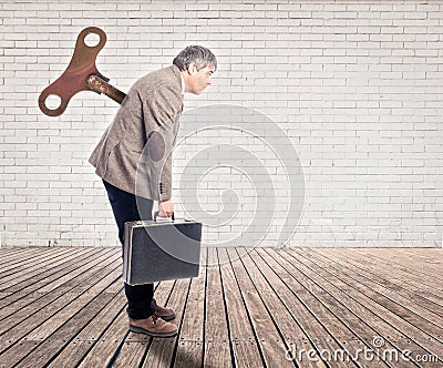 Businessman with a wind up key Stock Photo