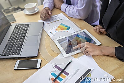 Businessman and woman discussing on stockmarket charts in office Stock Photo