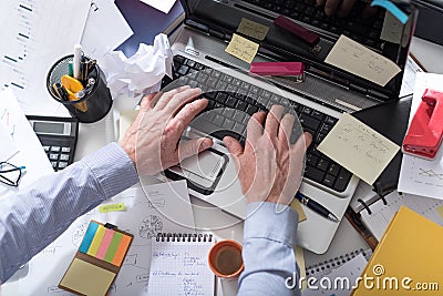 Businessman working on a cluttered and messy desk Stock Photo