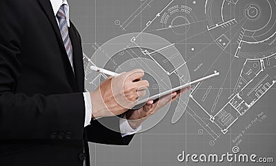 Businessman working on digital tablet with Architectural blueprint plan drawing background, architect, real estate business Stock Photo