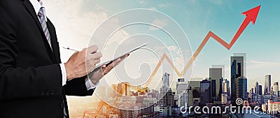 Businessman working on digital tablet, with panorama city view and raising up graph and arrow, representing business growth Stock Photo