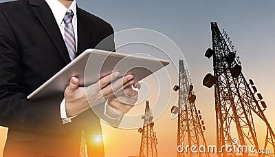 Businessman working on digital tablet, with satellite dish telecom network on telecommunication tower in sunset, telecommunication Stock Photo