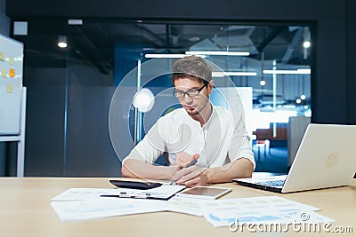Businessman working with documents and schedules in a modern office, male auditor verifies the company`s financial report Stock Photo