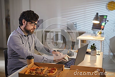Businessman working and eating at office Stock Photo
