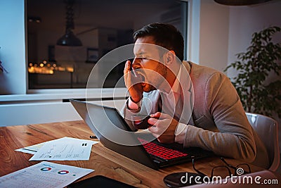 Businessman working on a laptop, overworking, under pressure Stock Photo