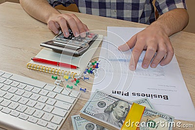 Businessman working on office desk with Calculator. Financial report values with dollars, calculator Stock Photo