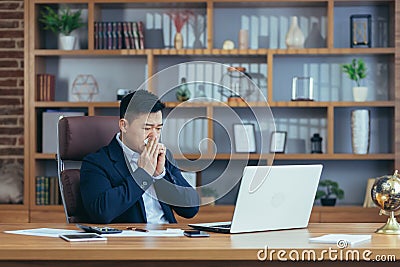 Businessman working in the office, sick Asian has a cold and flu, runny nose from allergies Stock Photo