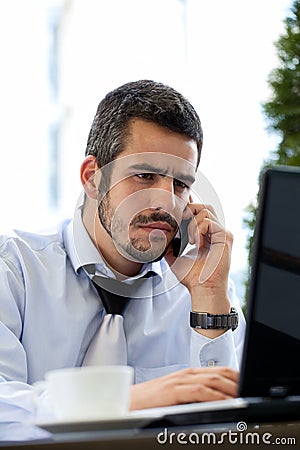 Businessman working outdoor with mobile and laptop Stock Photo