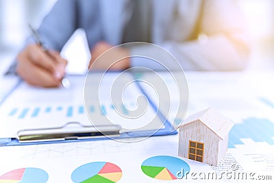 Businessman write business plan with chart and home Stock Photo