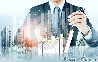 Businessman write increasing graph with city background Stock Photo