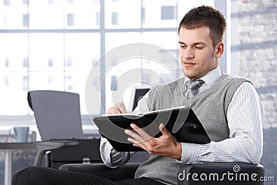 Businessman writing notes to personal organizer Stock Photo