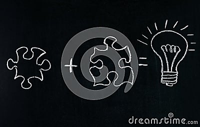 Businessmans Hand drawing puzzle on blackboard to explain business concept. Solving puzzle together. Drawing light bulb on blackbo Stock Photo