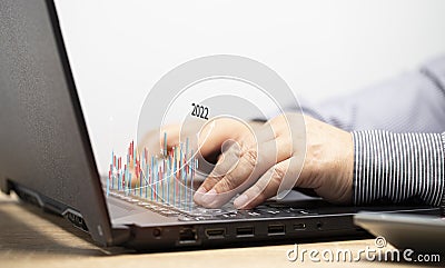 Businessmen conduct online stock trading transactions by his notebook. The stock chart is in an uptrend. Make trading decisions Stock Photo
