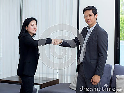 businessmen giving fist bump after business achievement in meeting room. Stock Photo