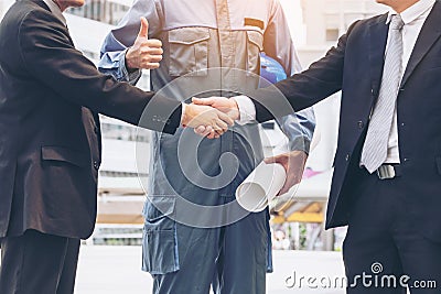 Businessmen handshake with engineer thumbs up Stock Photo