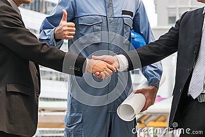 Businessmen handshake with engineer thumbs up Stock Photo