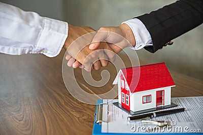 Businessmen and investors in house trading.Holding hands to trust. Hand in hand to make a home purchase contract.Hand in hand with Stock Photo