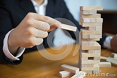 Businessmen picking wood blocks to fill the missing dominoes. Growing business concept Stock Photo