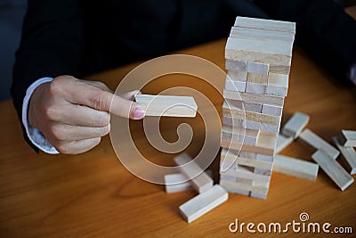 Businessmen picking wood blocks to fill the missing dominoes. Growing business concept Stock Photo