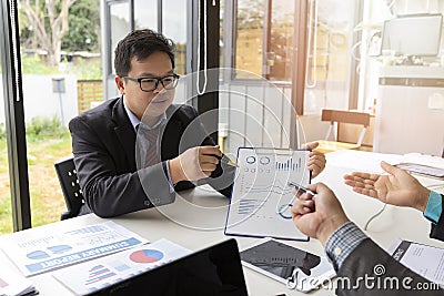 Businessmen present earnings report , the monthly college budget, financial chart to colleagues in the meeting Stock Photo