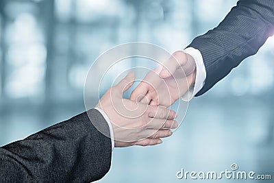 Businessmen reach out to each other to shake hands Stock Photo