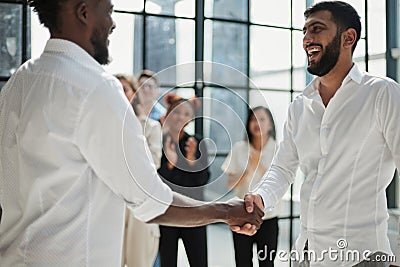 Businessmen reach out to each other to shake hands Stock Photo