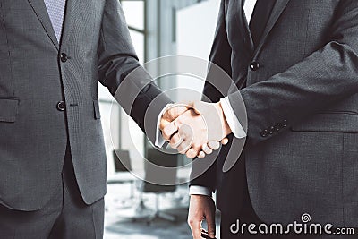 Businessmen shake hands in loft conference room Stock Photo