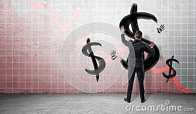 Businessmen on statistical chart background placing hands on a wall with black painted dollar signs and hand prints. Stock Photo