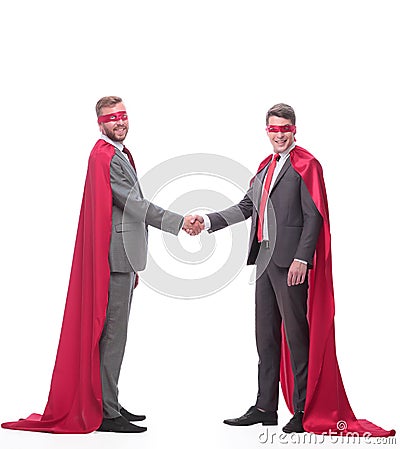 Businessmen in superhero capes, shaking hands with each other Stock Photo