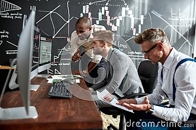 Today, tomorrow, together. Businessmen, traders in shirts discussing strategy and collaborative process in office Stock Photo