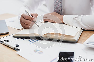 Businessmen use graphs to summarize results and calculate income-expenses to find financial balance points and use them to improve Stock Photo