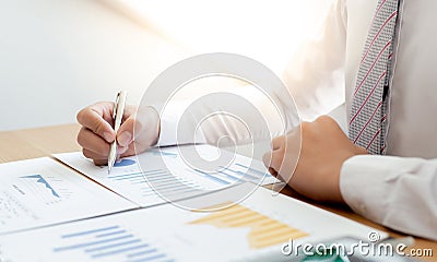 Businessmen use graphs to summarize results and calculate income-expenses to find financial balance points and use them to improve Stock Photo